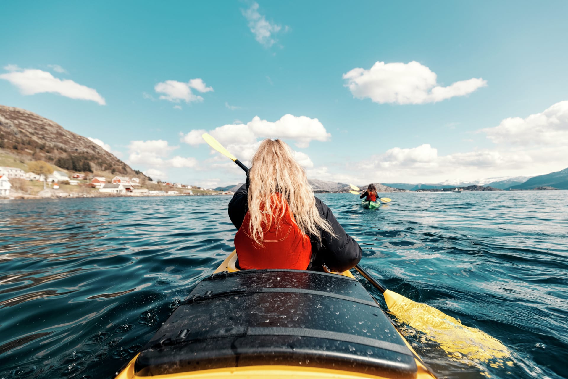 To kajakkpadlarar på fjorden i Bremanger ein solfylt dag